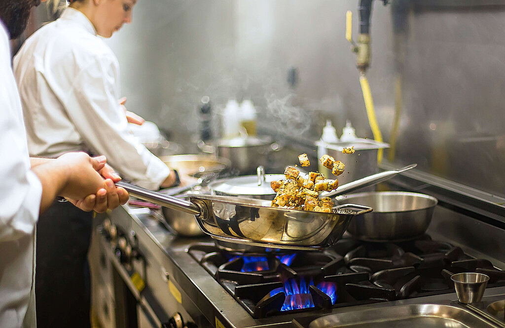 Köche in der Gastronomie am Kochen eines Gasherd