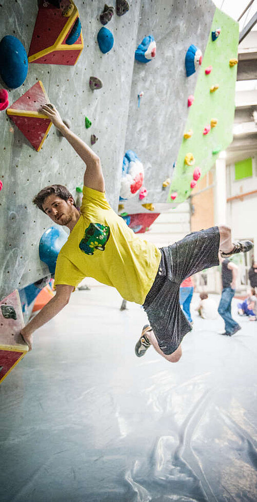 Person bouldert an Kletterwand in Rock Town Kaiserslautern