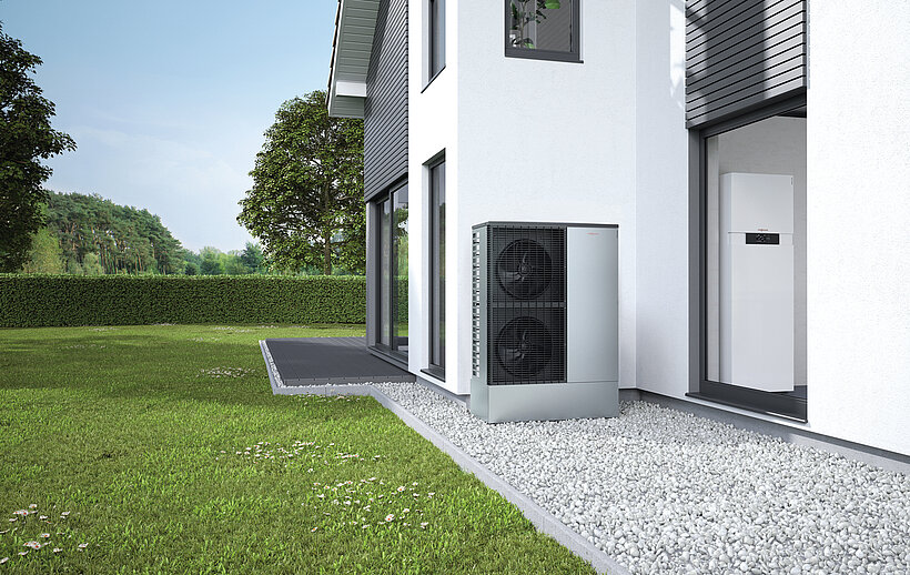 Wärmepumpe vor Hauswand.
