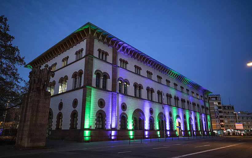 Fruchthalle angestrahlt von blauen, grünen Lichternbei Dunkelheit