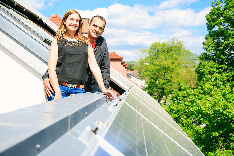 Paar neben Solar-Anlage auf Dach