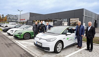 Schnellladestation vor Porsche-Zentrum in Kaiserslautern, daneben stehend Personen der SWK und Porsche