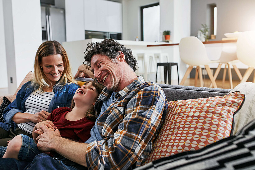 Mann, Frau und Kind auf Couch 